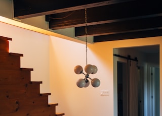 round brown wooden table and chairs under white pendant lamp