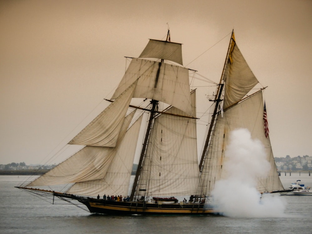 brown and black galleon ship on ocean water under gray sky