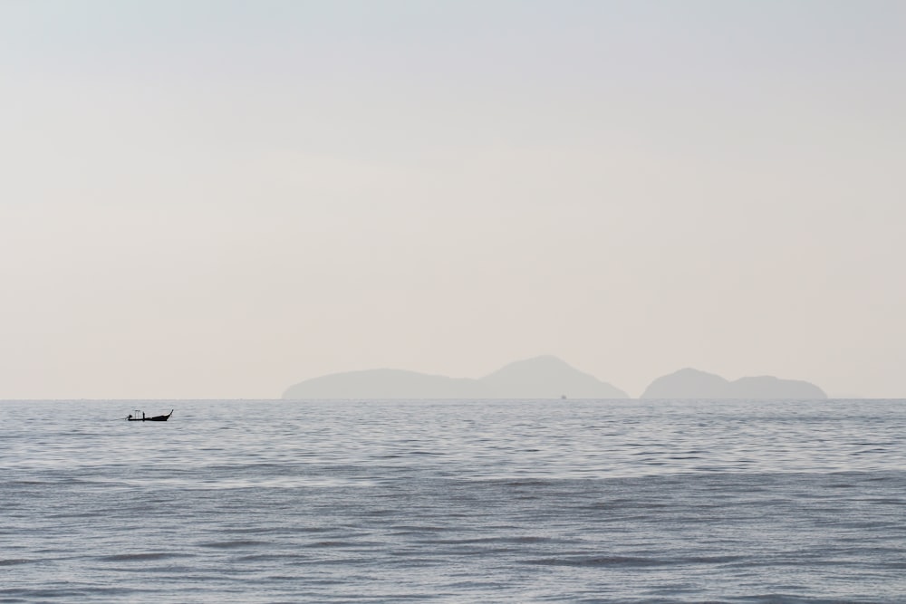 silhouette of boat sailing on ocean