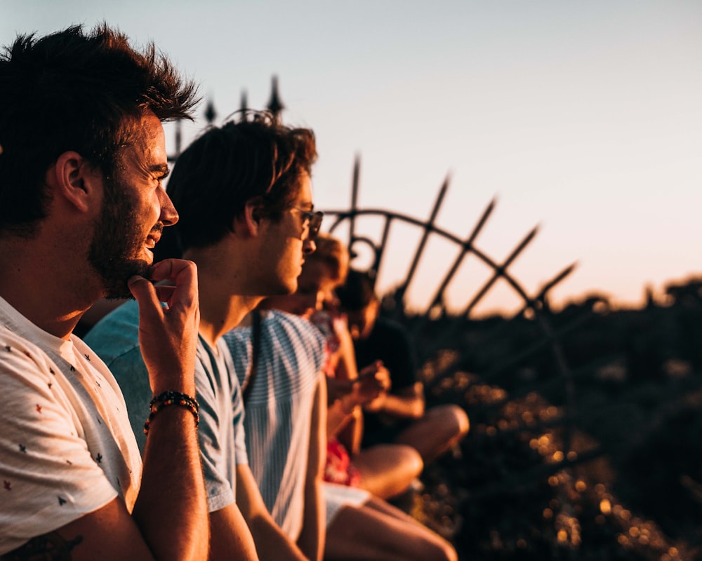 man sitting on fence facing right way under golden hour