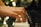 Hands gracefully play the keys of a piano with blurred bokeh lights creating a soft, serene background.