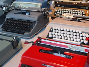 A collection of various antique typewriters displayed on shelves.