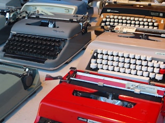 A collection of various antique typewriters displayed on shelves.