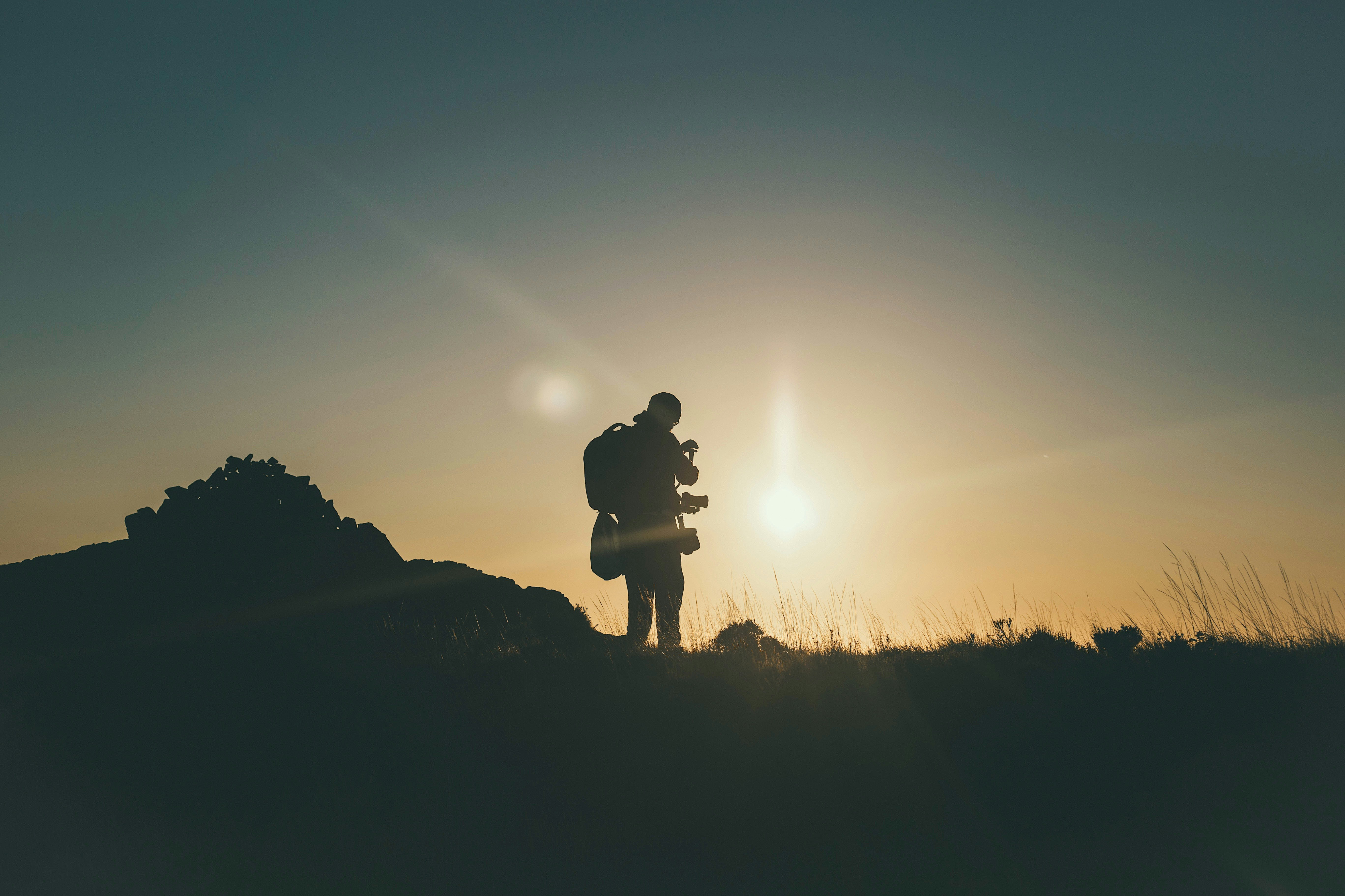 silhouette of mountain climber at golden hour