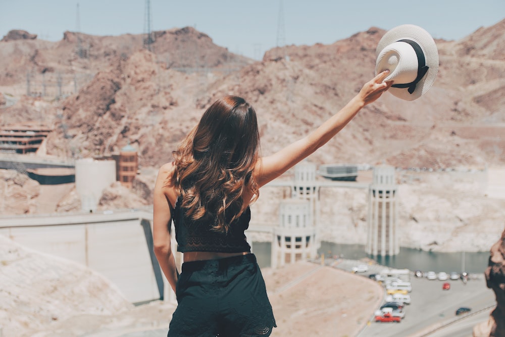 Femme levant un chapeau