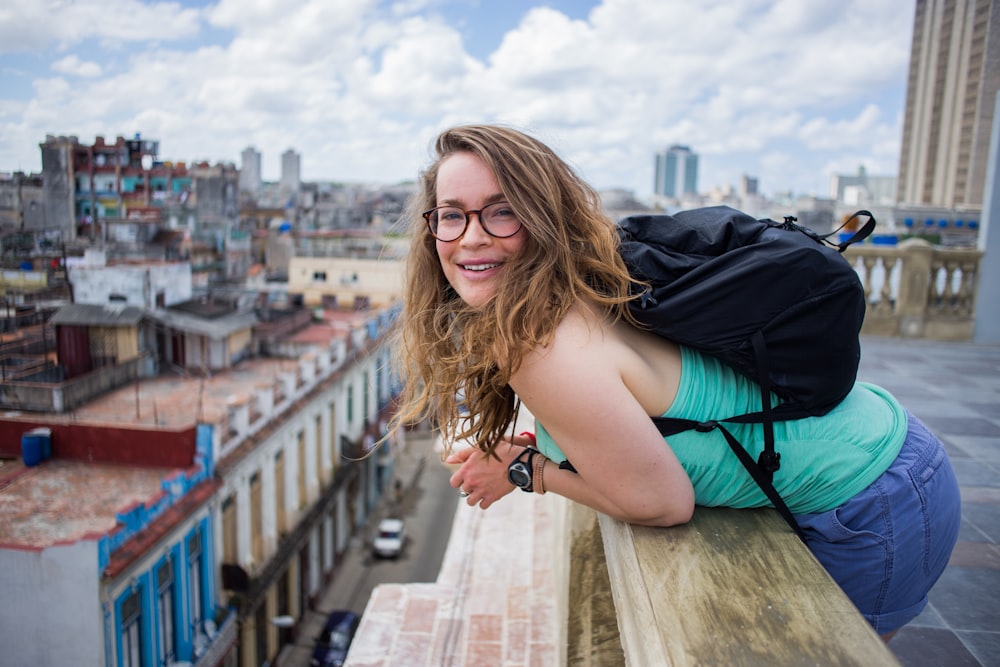 mulher inclinada na varanda durante o dia