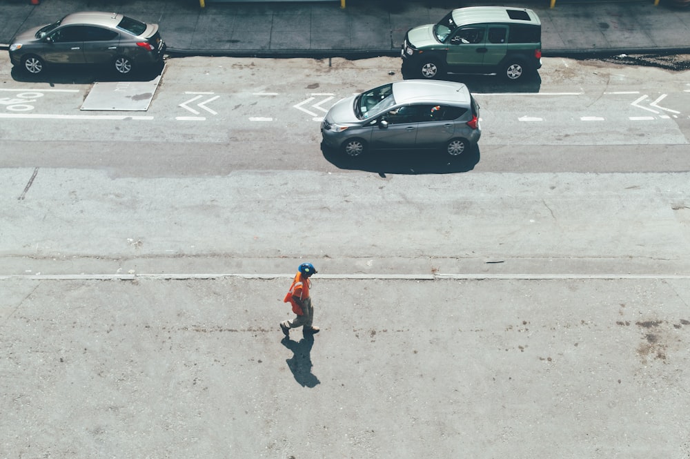 person walking on road near vehicles at daytime