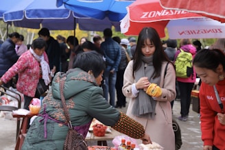 A journalist taking notes while interviewing a local resident in a busy market.