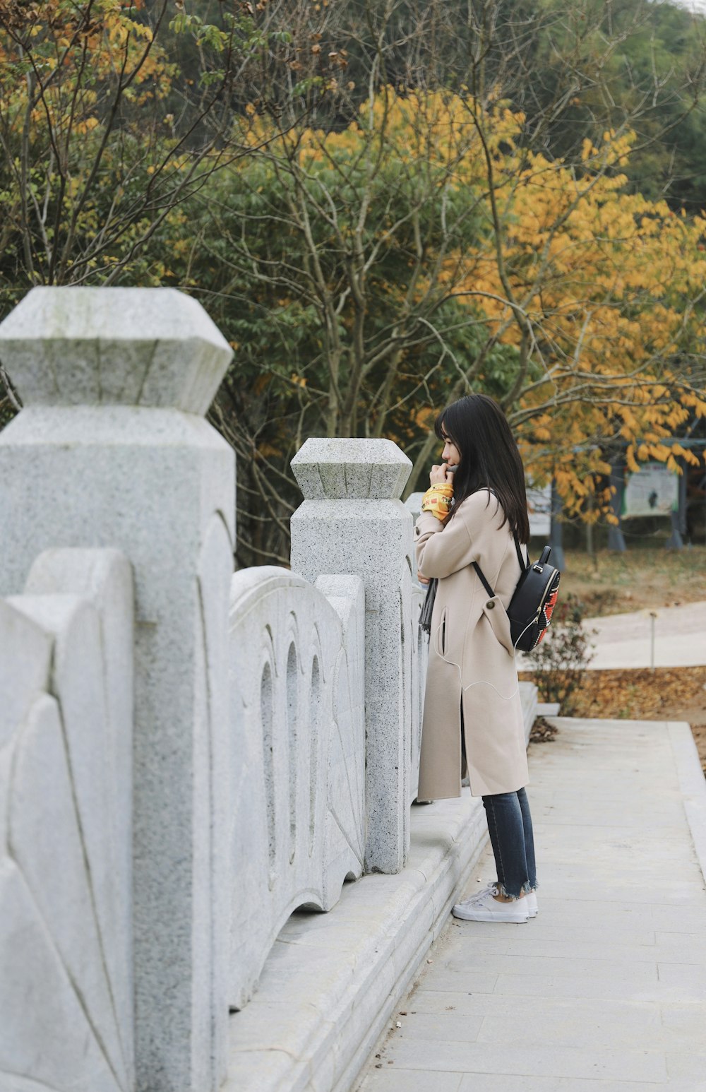 woman standing in front of concrete rail during daytime