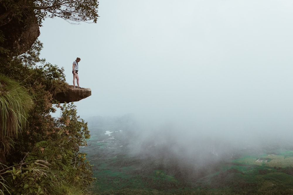 person standing on mountain cliff