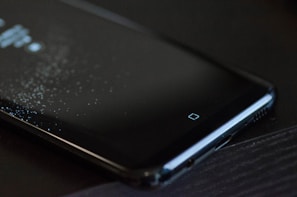 A sleek smartphone resting on a table with a fantasy game loading