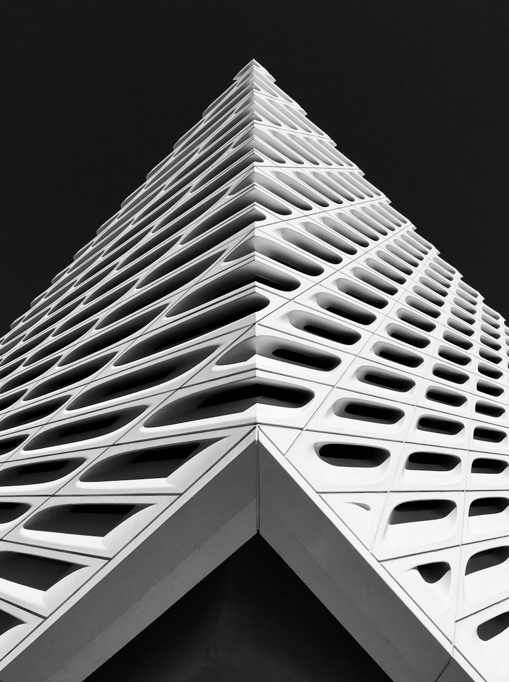 Un edificio alto y blanco con un fondo de cielo