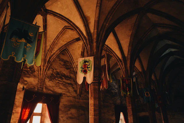 A cozy medieval tavern interior with wooden beams, flickering candles, and ancient scrolls scattered on a rustic table.