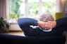 man lying on black couch