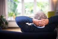 man lying on black couch