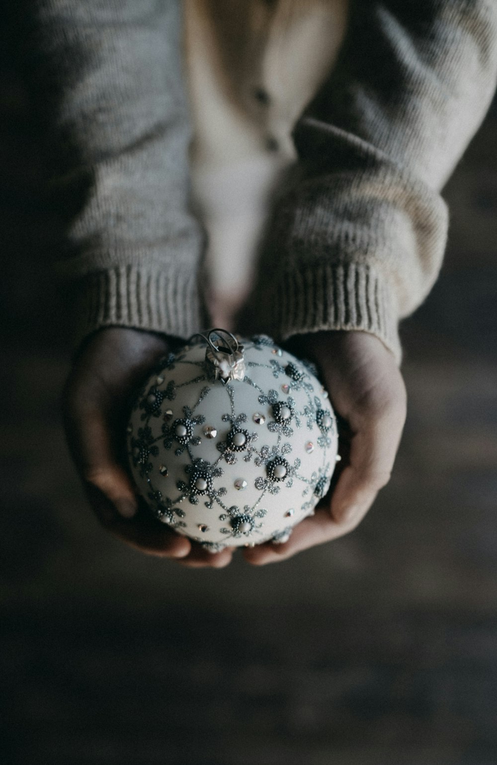 personne tenant une boule de Noël