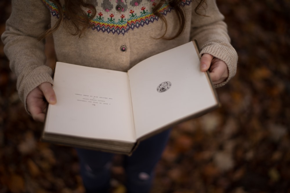 girl reading book closeup photography