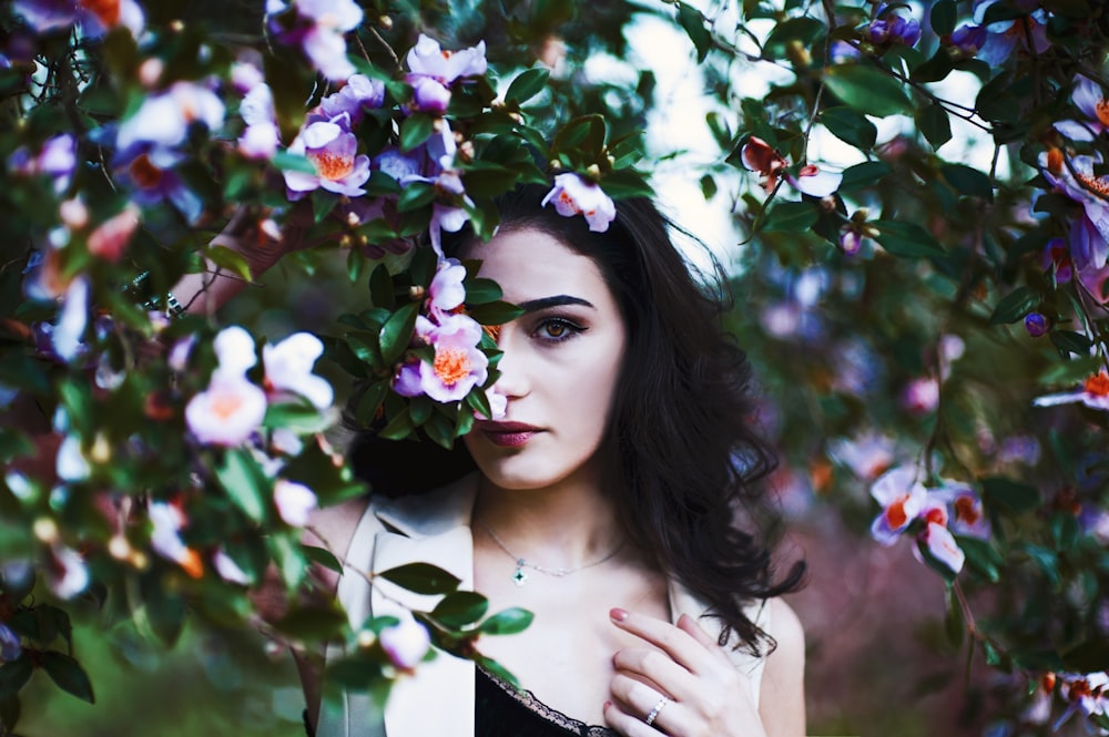 selective focus of woman hiding on flowers during daytime