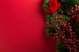 a close up of a christmas wreath on a red background