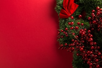 a close up of a christmas wreath on a red background
