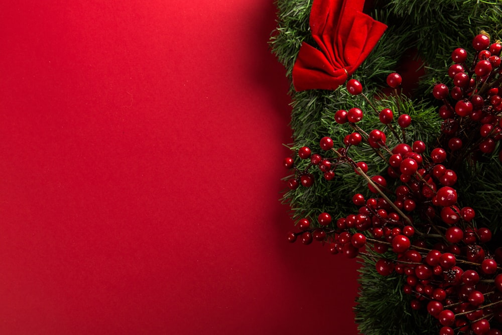 Un primo piano di una ghirlanda di Natale su uno sfondo rosso