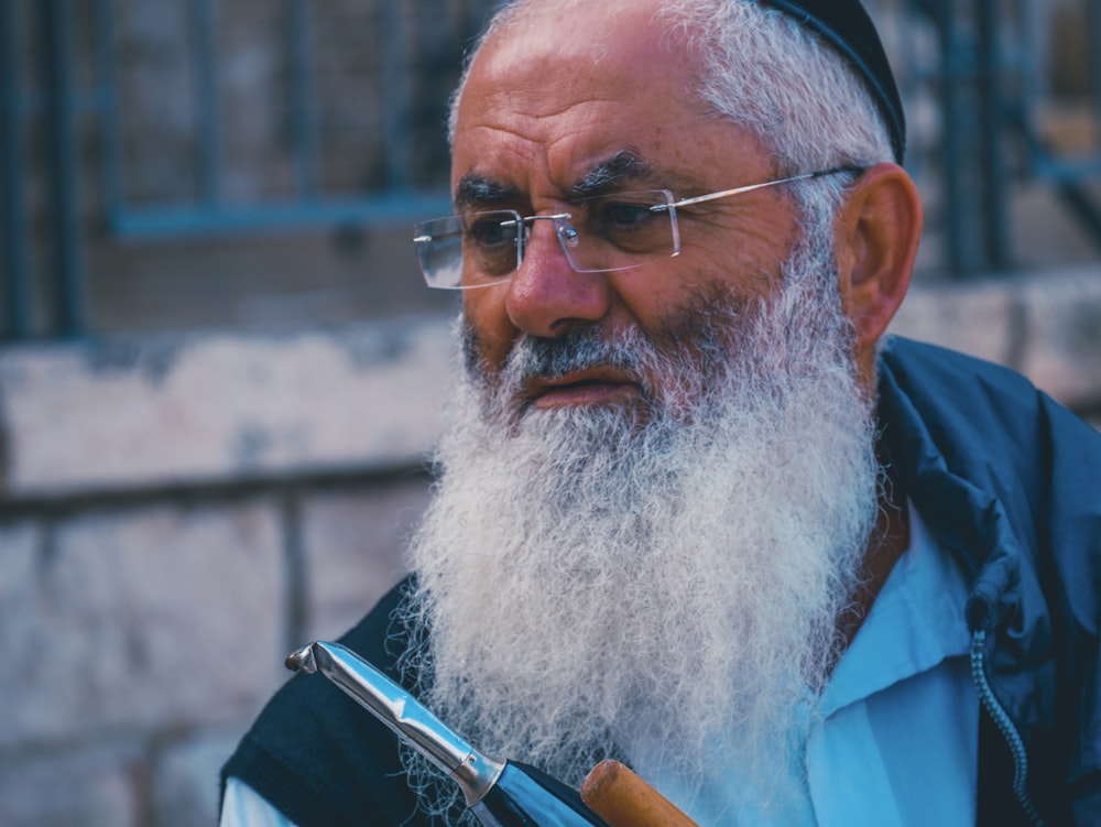 person holding stainless steel tool wearing silver framed eyeglasses