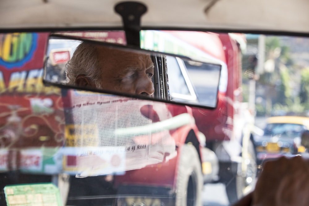 vehicle rear-view mirror showing person looking outside