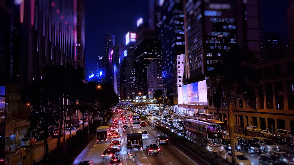 carros que viajam na estrada entre edifícios durante a noite