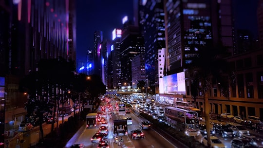 cars travelling on road between buildings at night time in Hong Kong Island Hong Kong