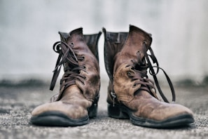 Durable men's boots on a rustic outdoor background.