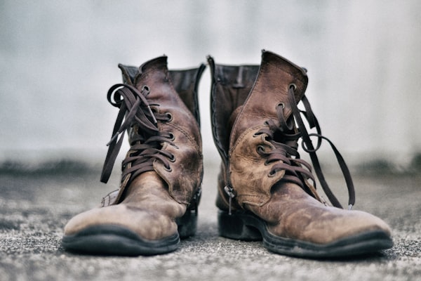 An old pair of brown shoes, unlaced