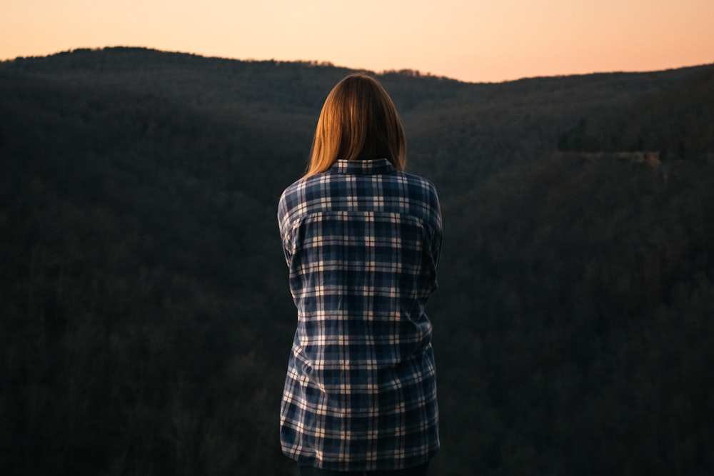 woman standing while facing the mountain