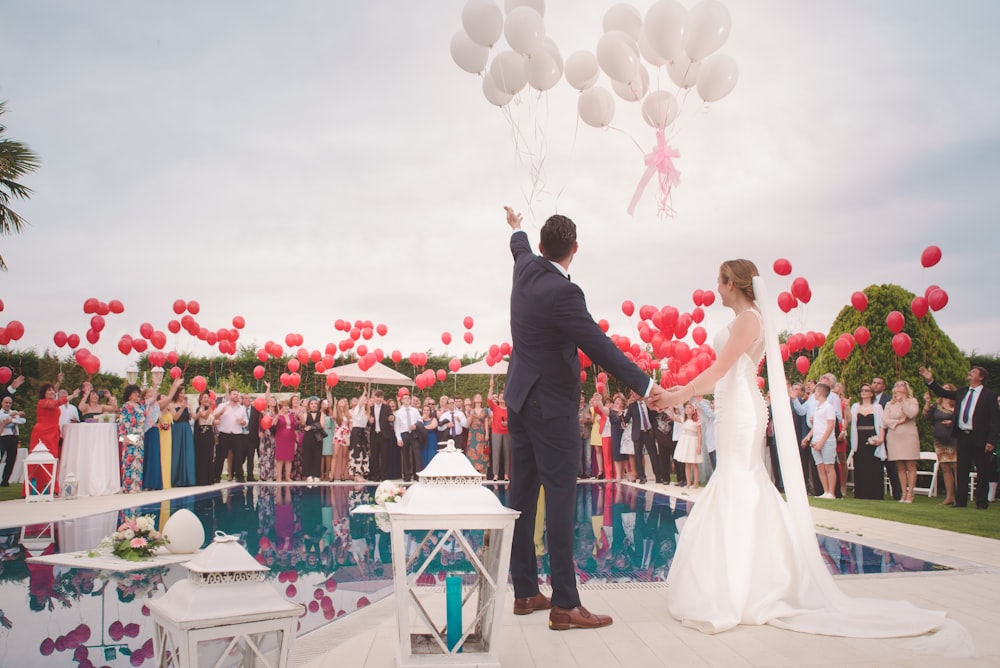 foto de un hombre y una mujer recién casados sosteniendo un globo