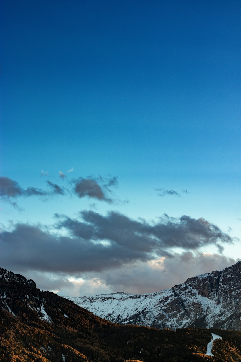 dark clouds over snow capped mountains