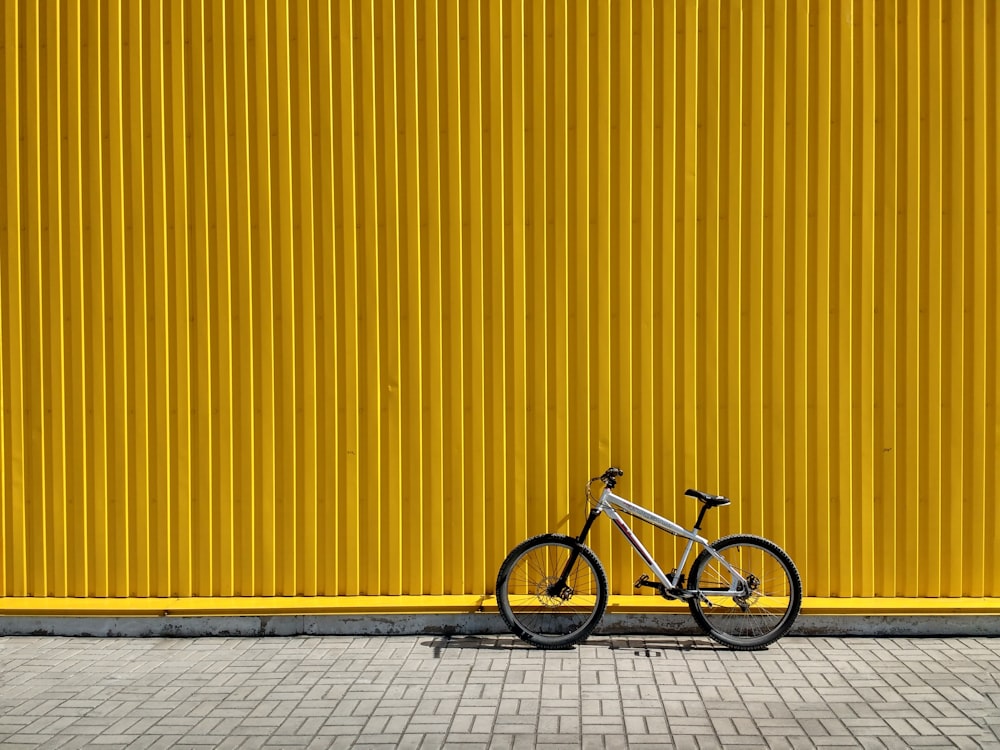 graues und schwarzes Fahrrad lehnt an der Wand