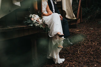 bride and groom sitting and holding their hands