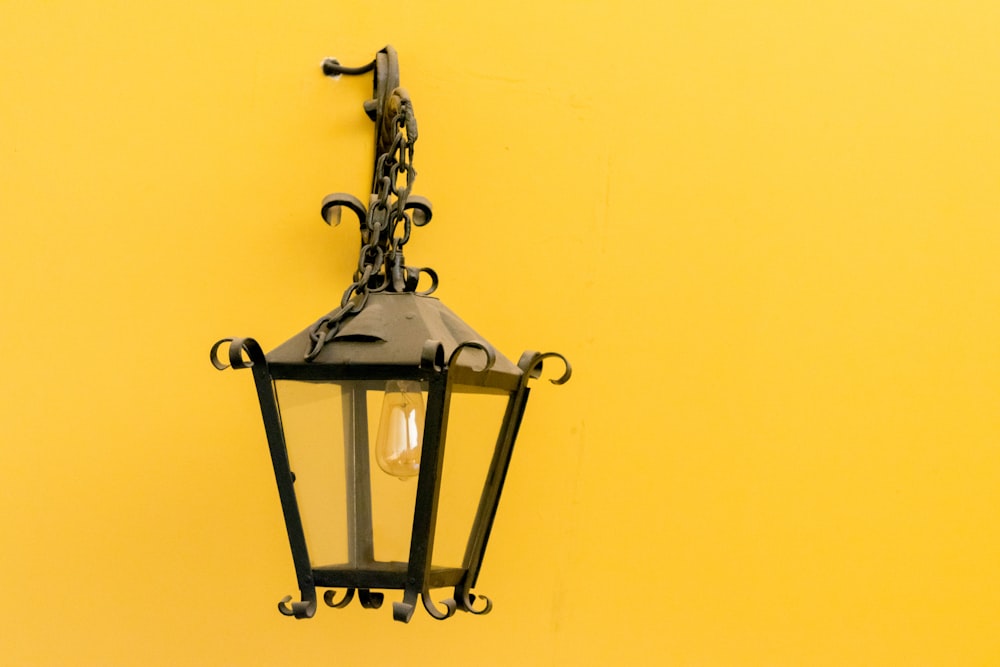 black sconce lamp on yellow wall
