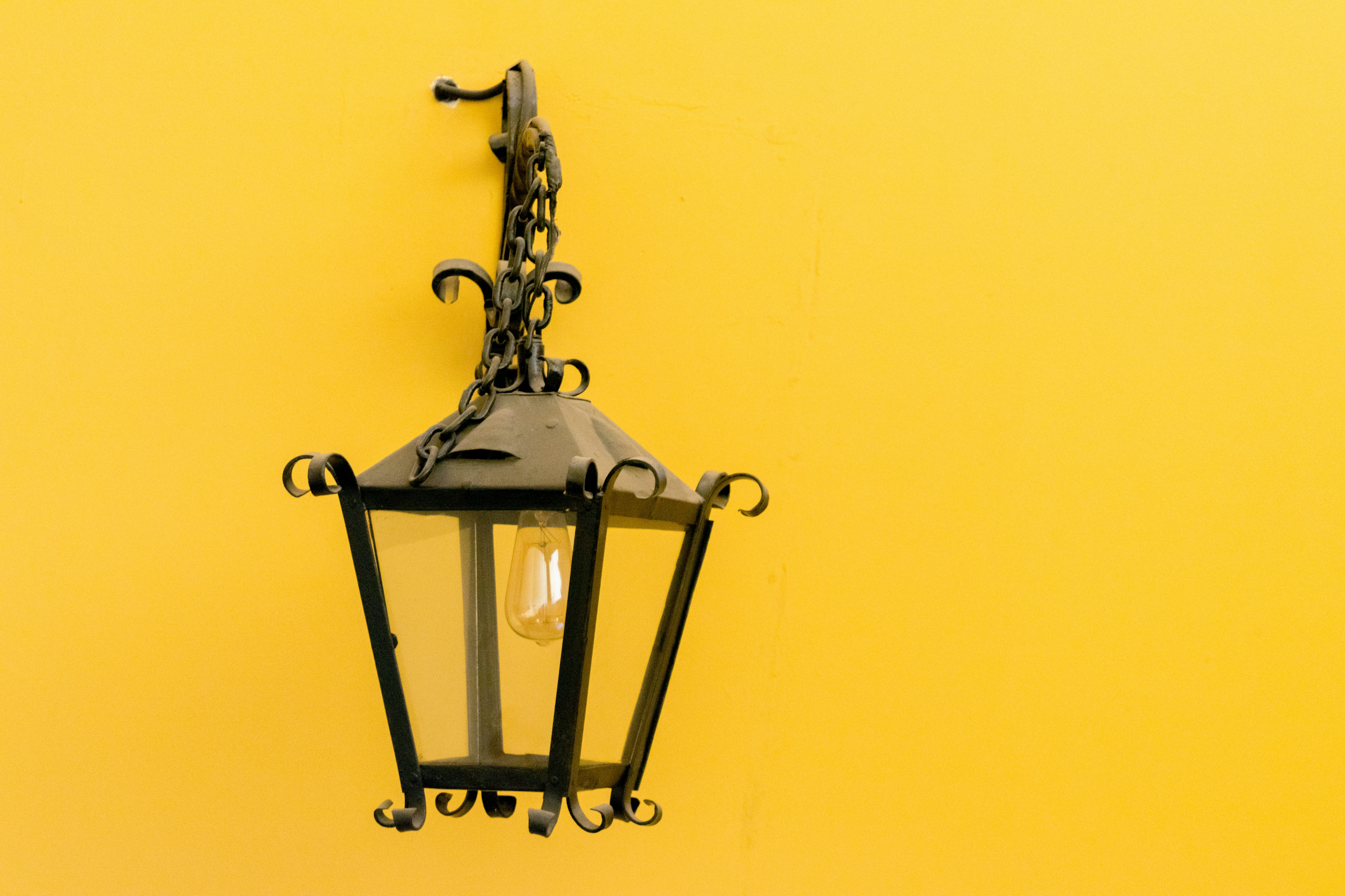 black sconce lamp on yellow wall