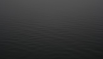 a large body of water with a boat in the distance