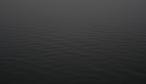 a large body of water with a boat in the distance