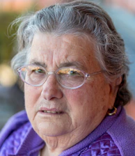 Senior woman wearing a sleek Emotiv Insight headset in a calm, blue-green ambient room.