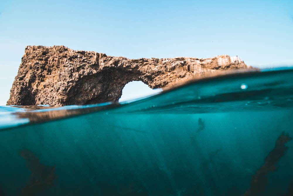 brown rock over body of water