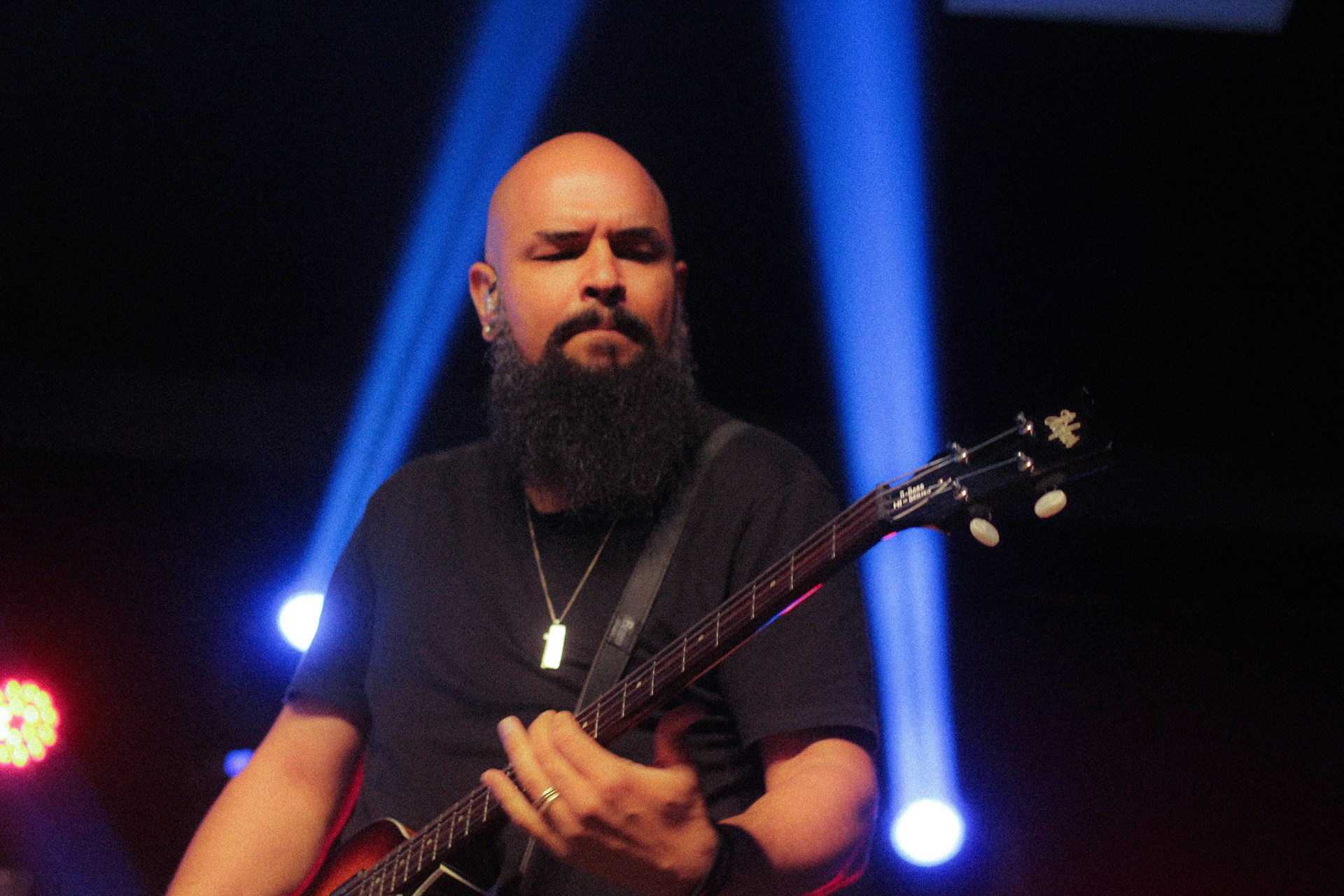 Paco Lomeña passionately playing flamenco guitar on stage with dramatic lighting highlighting his intense expression.