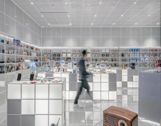 man walking beside white cube decoration