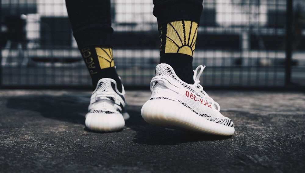 person wearing zebra Adidas Yeezy BOOST 350 v2's