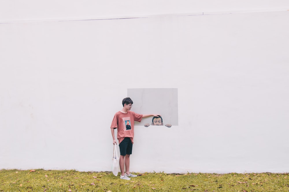 boy standing near white wall