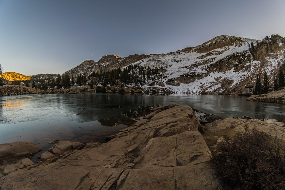 rockformation near lake under white sky