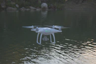 A GPS drone hovering steadily over a sparkling lake reflecting the sky.
