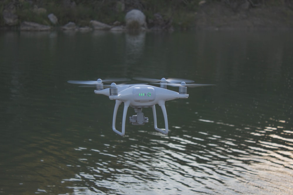 quadcopter flying above body of water