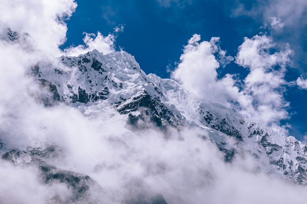 snow covered mountain surround by fogs at daytime